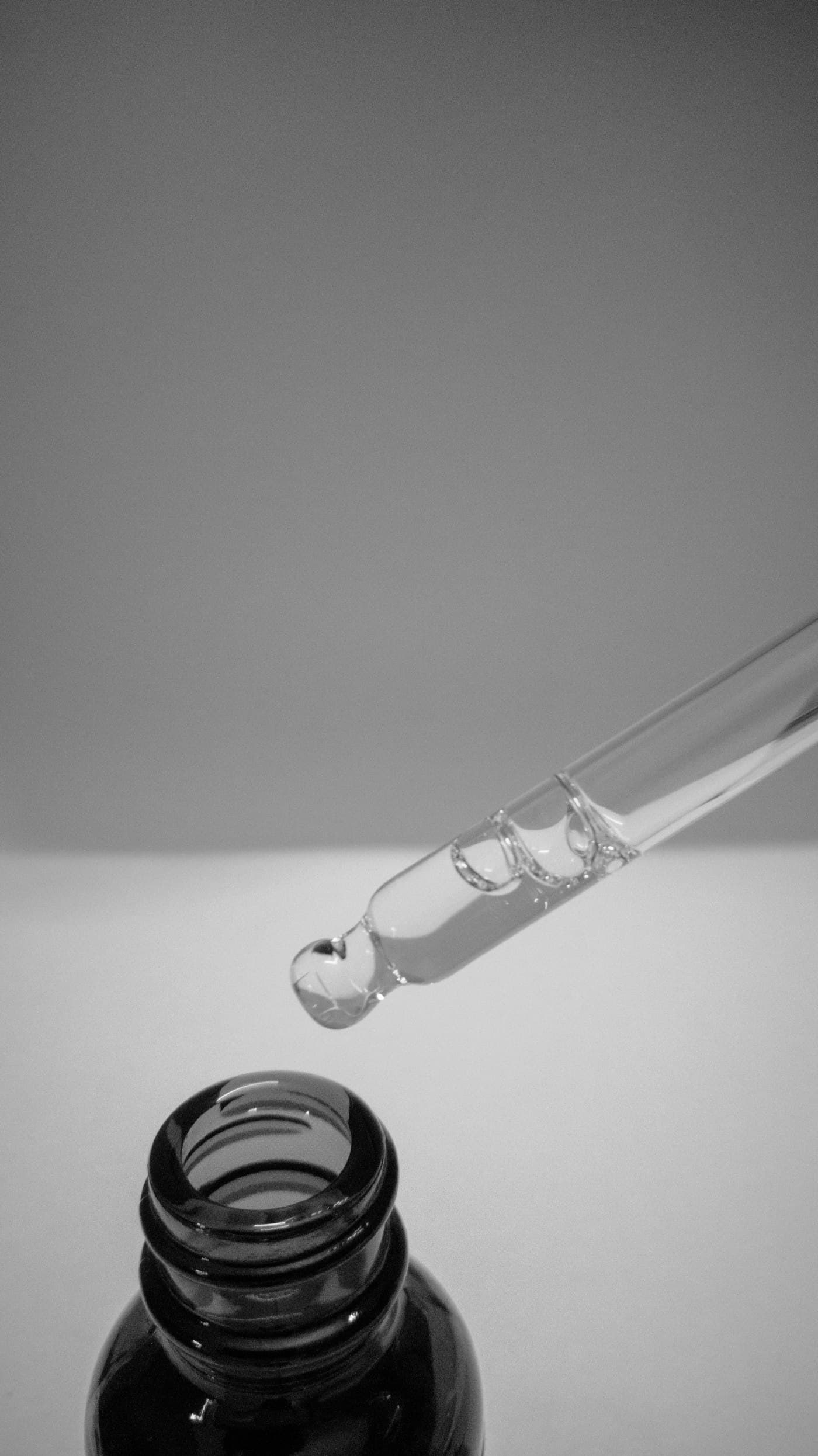 Macro of a glass dropper and serum droplet